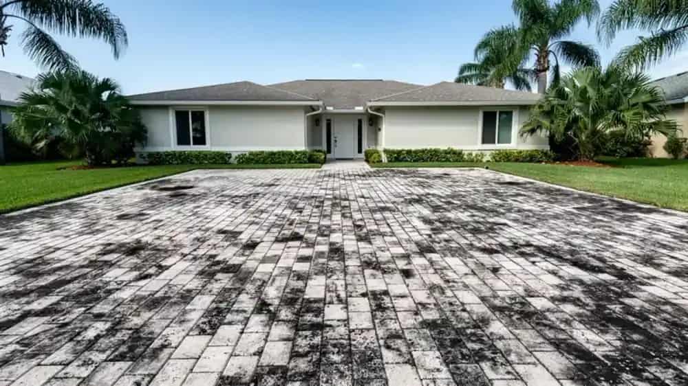 Signature Shine technician pressure washing a paver driveway